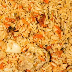 Uzbek pilaf.Pilaf with chicken and spices.Pilaf with meat background.The texture of pilaf.Rice pilaf with chicken.