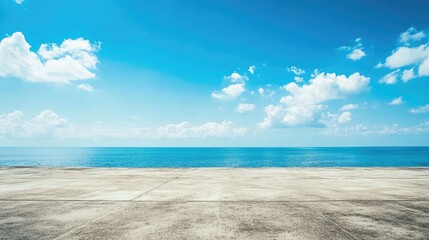 Fototapeta premium Expansive blue sky with scattered clouds over a smooth concrete surface, featuring a calm sea view, ideal for promotional banners and serene visuals.