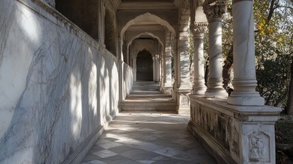 Obraz premium Elegant marble pillars framing the entrance of a grand hallway, with natural light casting soft shadows on the polished stone floor.