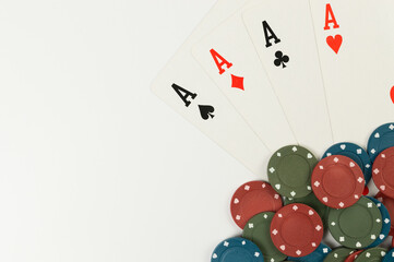 Top view of playing cards, poker chips on white background. Four aces cards, board game, poker. Copy space, flat lay.