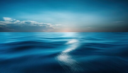 Obraz premium Serene Twilight Sea: A mesmerizing seascape at twilight, where the deep blue ocean meets a soft, cloudy sky. The tranquil scene evokes a sense of peace and wonder.