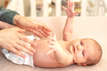 Naklejka premium Newborn baby. A mother changes the diapers of a newborn.