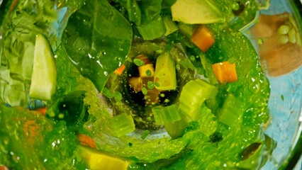 Fresh fruit and vegetables smoothie blended in blender, top view. Healthy eating concept. Freeze motion.