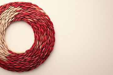 a golden wreath with red accents, A beautifully woven wreath in red and cream colors, perfect for home decoration or festive celebrations.