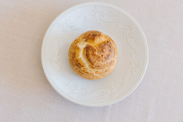 choux cream or cream puff or French profiteroles with fresh cream set on cafe table