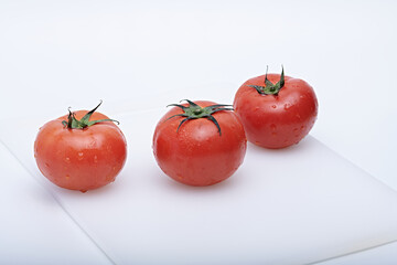 Fresh red tomatoes healthy vegetables photographed on white background and mat
