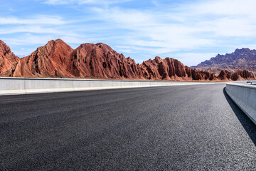 Asphalt road and Danxia landform mountain natural landscape in Xinjiang, China. Outdoor natural background.