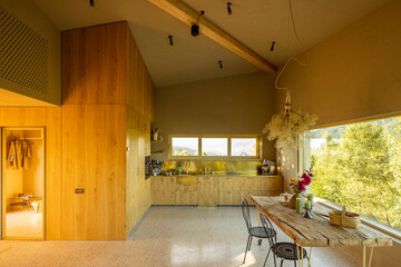 A cozy rustic kitchen with a natural wood design, featuring a charming dining table decorated with...