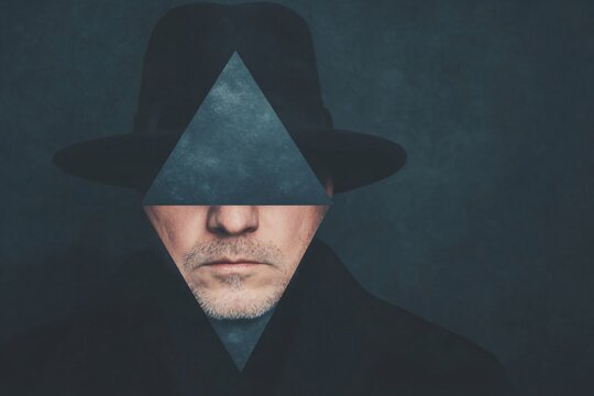 Mysterious figure in black hat and coat on dark background. Atmospheric portrait in noir style. Criminal detective concept with moody lighting and triangular element with copy space