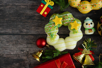 Top view of donut and Christmas decorations on wooden background