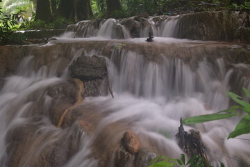 Obraz premium Travel to waterfalls during the rainy season, The tiers of the waterfall contrast beautifully with the sky