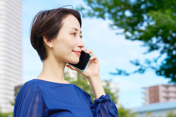 屋外でスマホで電話する女性