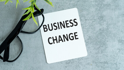 Business Change - business concept. text at canvas with wood stand and pen on grey table