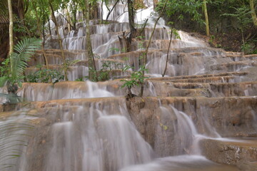Obraz premium Travel to waterfalls during the rainy season, The tiers of the waterfall contrast beautifully with the sky, Nature itself is the best physician
