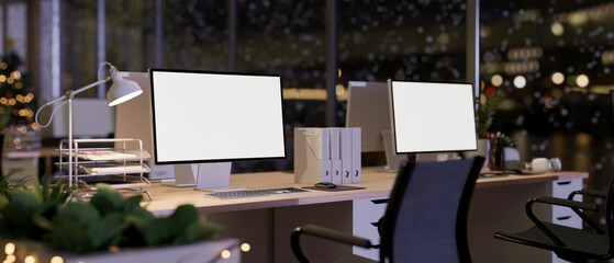 A modern office inside a skyscraper on a Christmas winter night features sleek computer desks.