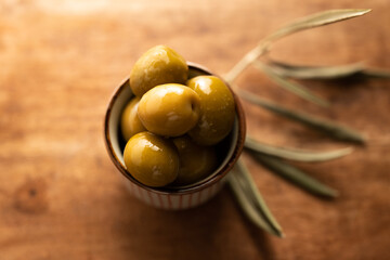Fresh Green Olives in a Bowl on a Wooden Table
