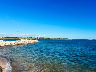 Serene coastal scene with clear blue water and rocky shoreline