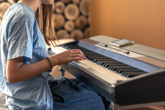 Female hands on the piano. The girl plays the piano. Musical instrument.