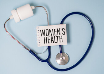 Stethoscope on note book with Women's Health words as medical concept