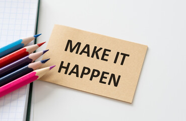 Make It Happen inscription on a card with colored pencils on a white background