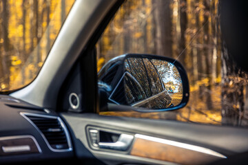 Rear view side mirror of a car. Seen through the rear view mirror.