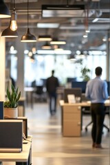 Blurred office space with employees and hanging lights