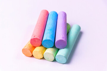 Crayons of different colors arranged on a white background. Education
