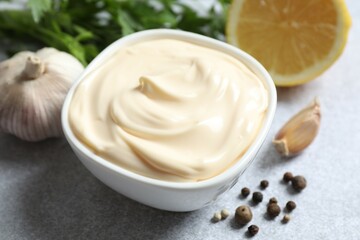 Bowl with mayonnaise on gray background