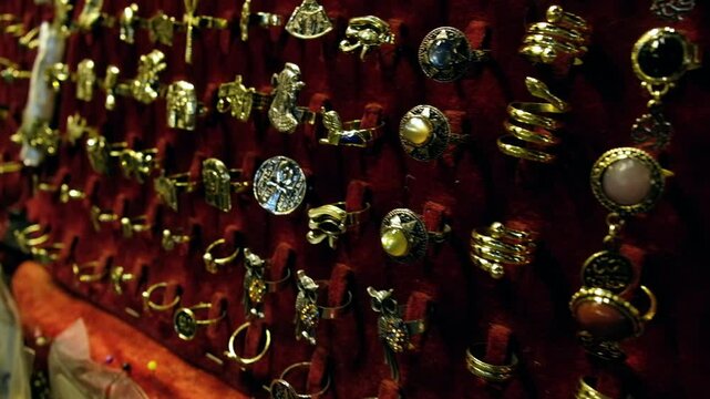 Rows of golden jewelry signets with semiprecious stones at traditional middle eastern bazaar. Jewelry rings for sale at Khan El Khalili bazaar, Cairo, Egypt