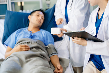 Obraz premium Hospital Ward Male and Male Professional Asian Doctors Talk with a Patient, Give Health Care