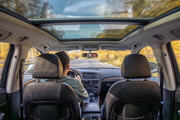 Driving the modern car on asphalt road. A young man drives a car.