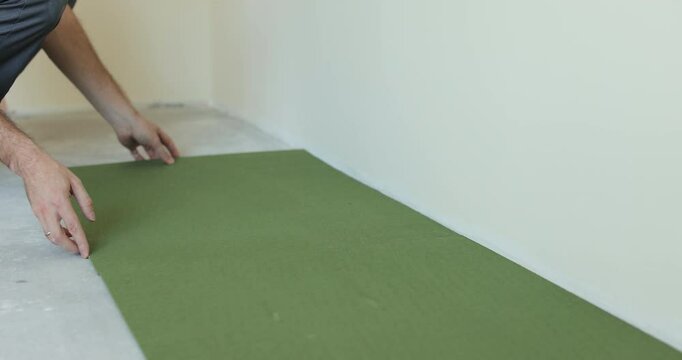 Laying underlay for the laminate flooring. Preparatory work before laying a laminate board. Laying a polypropylene substrate under the laminate. Renovation of a new house.