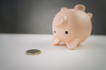 Inverted piggy bank, spilled gold coins. Opening piggy bank. last coin from the piggy bank. The...
