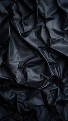 Obraz premium A textured, dark fabric with intricate folds and creases, creating a rich, dramatic visual appearance.