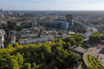 A stunning aerial view of central London showcasing modern skyscrapers, lush greenery of St. James's Park, and iconic architectural landmarks under a vibrant blue sky