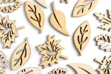 Different types of delicate light brown laser cut wooden leaf on white background.