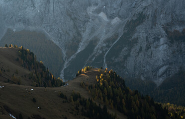 sunlight lighting up fall colors in the dolomite mountains