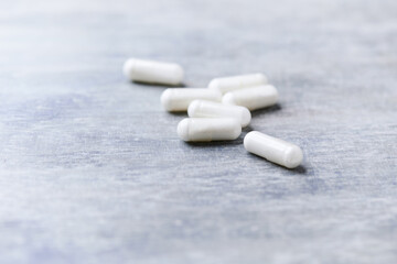 Beta-alanine capsules. Bodybuilding food supplements on wooden background. Soft focus. Close up. Copy space.	
