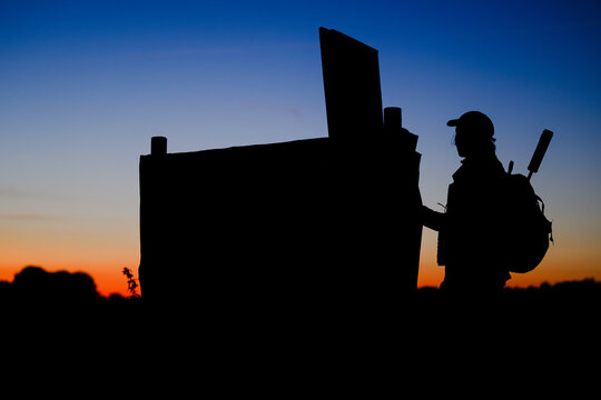 J&auml;gerin am Hochsitz im Sonnenuntergang