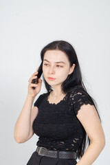 Cute young brunette communicating with smartphone on a white background. Copy space