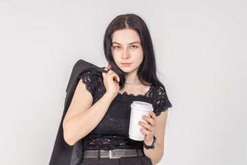 Cute young brunette with a coffee cup on a white background. Copy space