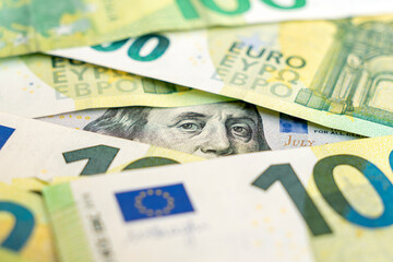 Euro and dollar notes. euro against dollar. A closer look of the president of the USA with a dollar bill, peeping out from behind a euro bill. USA and Europe finance relation. Close up top view.