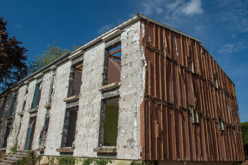 Fototapeta premium Vue extérieur d'un petit immeuble à démolir , il ne reste que l'armature en béton et la charpente en bois