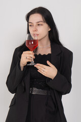 Cute young brunette girl with a wine glass on a white background