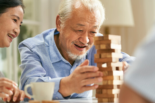 happy asian old people playing with building blocks at home