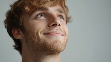Obraz premium Thoughtful Young Man Smiling with Natural Light and Soft Background