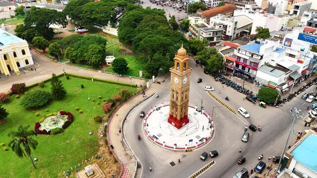 Drone shot of Mysore's bustling city center in Karnataka, highlighting a vibrant roundabout, urban structures, and nearby greenery. South India.
