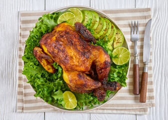 whole roasted chicken with avocado, lime on plate