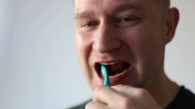 Man brushing his teeth with toothbrush. Fighting tooth decay
