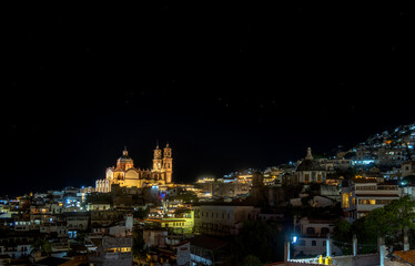 Night view of illuminated Taxco, Mexico, highlighting historic architecture and vibrant lights